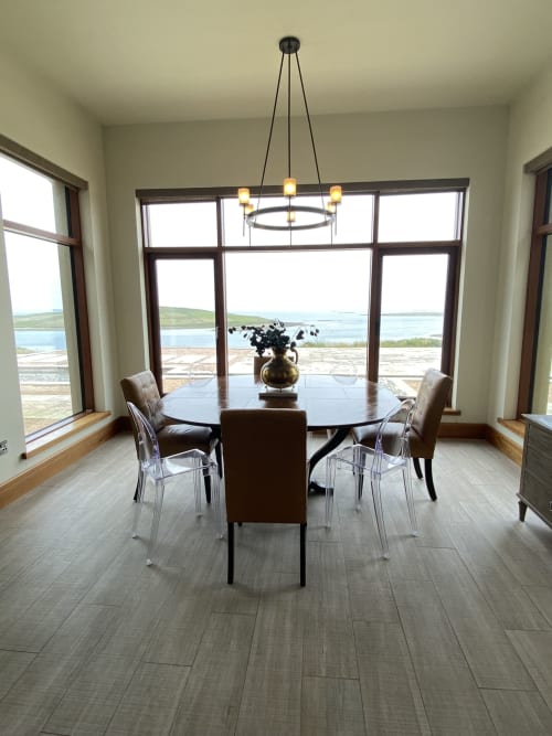 Modern dining room at Seabrook Lodge with round table, ocean views of Galway Bay, and pendant lighting