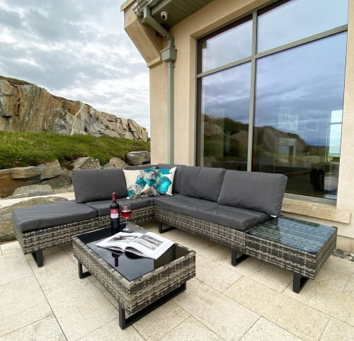 Outdoor patio seating at Seabrook Lodge in Clifden, Galway, with wicker furniture and rocky landscape views