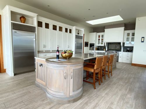 Modern kitchen at Seabrook Lodge in Clifden with white cabinetry, stainless steel appliances, curved island, and bar seating