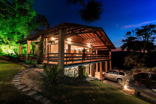 Villa Paraíso nas Montanhas ao anoitecer em Campos do Jordão com deck iluminado, vistas das montanhas e jardins paisagísticos