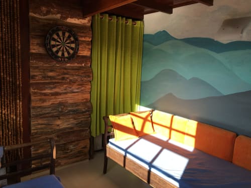 Quarto de suíte da vila com vista para as montanhas em Paraíso nas Montanhas, com paredes de madeira, cortinas verdes e painel mural com paisagem montanhosa em camadas