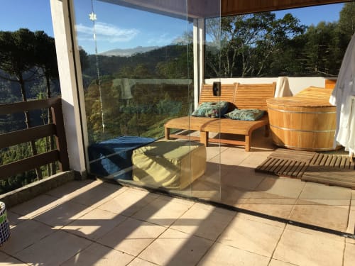 Terraço da villa de montanha Paraíso nas Montanhas com banheira de madeira, área de descanso e vista para o vale em Campos do Jordão