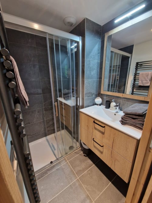 Modern bathroom in Serre Chevalier Cristal Lodge with shower, vanity, heated towel rack, and mirrors