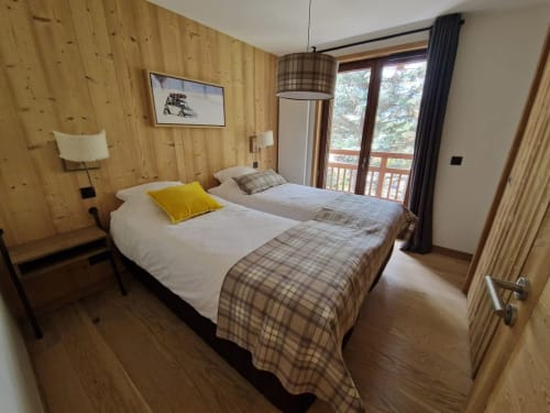 Twin bedroom in Serre Chevalier Cristal Lodge apartment with wood-paneled walls, mountain views, and modern furnishings