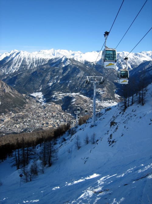 Vista aerea della funivia sulla valle alpina innevata e le montagne vicino a Serre Chevalier Cristal Lodge