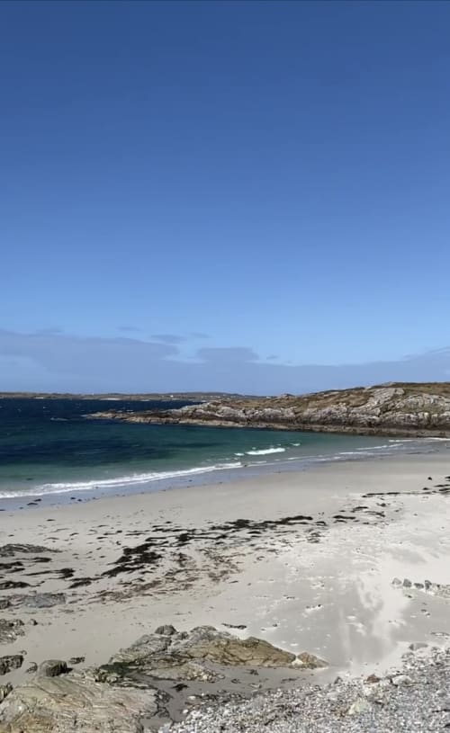 Pristine sandy beach with turquoise waters and rocky cliffs near Seabrook Lodge in Clifden, Galway