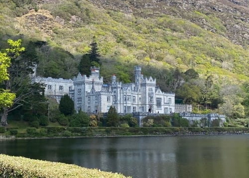 Seabrook Lodge castle hotel on the waterfront in Clifden, County Galway, Ireland, surrounded by lush green woodland and