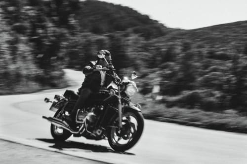 Motorcyclist riding through scenic countryside near Isigny-sur-Mer, France