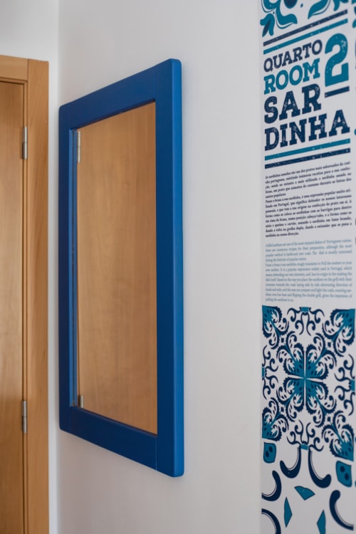 Espelho com moldura azul no quarto Sardinha da pousada Ó da Casa, Peniche, Portugal, com sinalização decorativa em azulejos de cerâmica portuguesa