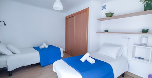 Duas camas de solteiro com mantas azuis no quarto Bordalo da pousada Ó da Casa em Peniche, Portugal