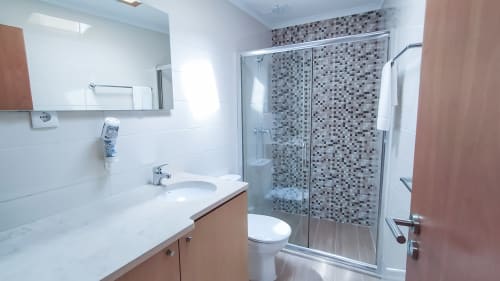 Banheiro moderno em Ó da Casa B&B em Peniche com chuveiro de azulejos mosaico, pia e vaso sanitário