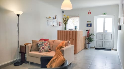 Salon accueillant de l'Ó da Casa B&B à Peniche avec canapé beige, éclairage chaleureux et décoration moderne