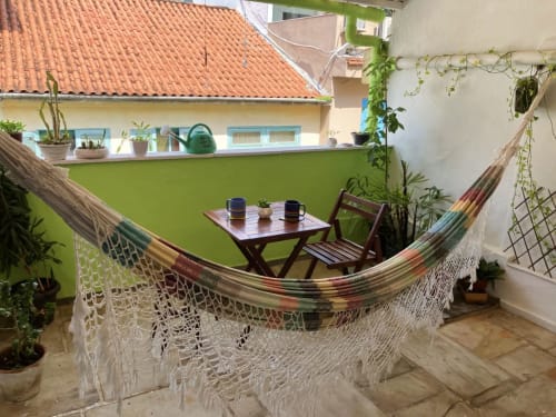 Aconchegante terraço na cobertura do Hostel New Ipanema com rede, mesinha e plantas exuberantes com vista para o Rio de Janeiro