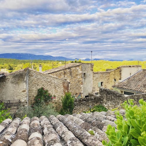 Bâtiments en pierre historiques aux toits de tuiles surplombant les vignobles de Grignan à La vie de château