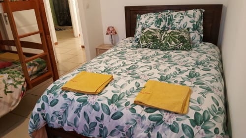 Chambre douillette à Case Vi D'O à La Plaine des Cafres avec linge de lit botanique et serviettes jaunes