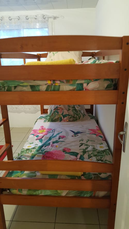 Lits superposés en bois avec literie fleurie à la Case Vi D'O, guesthouse à La Plaine des Cafres, île de la Réunion