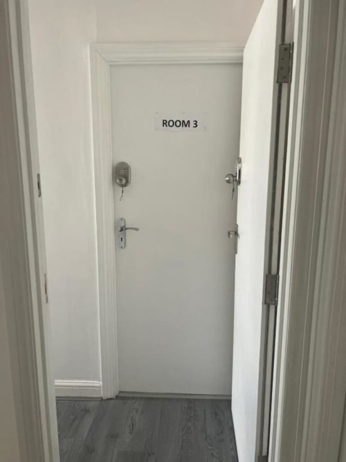Room 3 entrance at Starlet Property hotel in London with white door, security lock, and dark wood flooring.