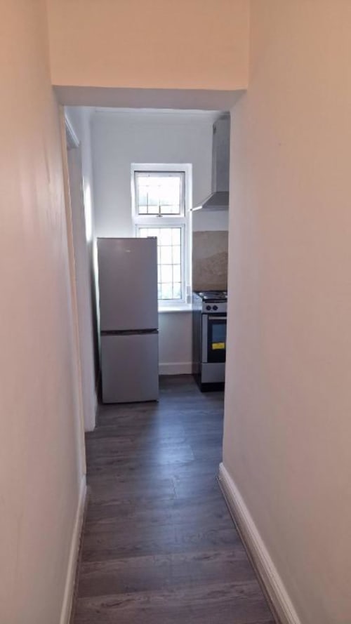 Hallway view of Room 4 at Starlet Property London hotel, leading to kitchenette with refrigerator and stove
