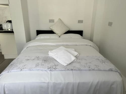 Studio 1 bed with white linens, cream pillow, and folded towels at Starlet Property, London