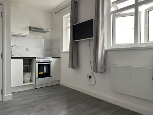 Modern kitchenette with stove, oven, and flat-screen TV in Starlet Property's Loft Studio in London