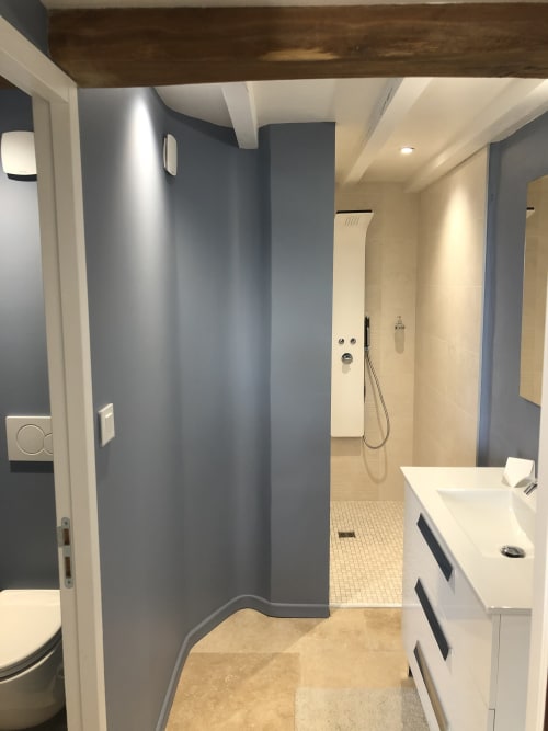 Salle de bains contemporaine au Château Haut Clarise avec douche à l'italienne, vasque blanche et accents gris ardoise