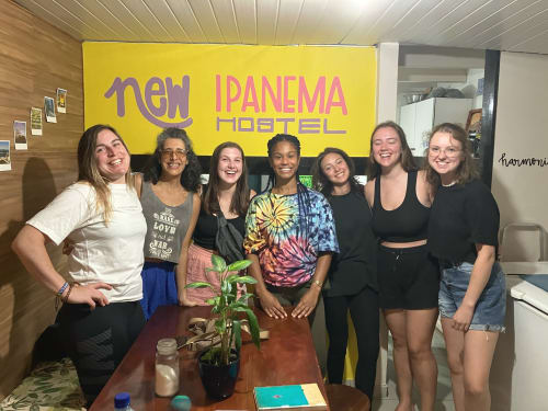 Membros da equipe sorrindo no balcão de recepção da Hostel New Ipanema no Rio de Janeiro