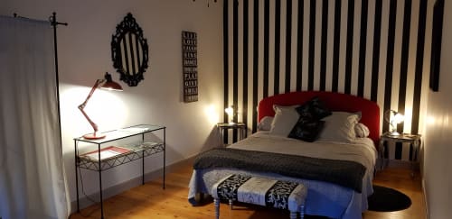Chambre moderne à Au Nid De La Madeleine Gaillac avec tête de lit rouge, mur à rayures, parquet et design contemporain