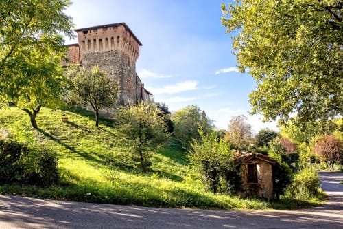 La torre in pietra medievale dell'Hotel Eden domina la lussureggiante collina verde di Vignola, Italia