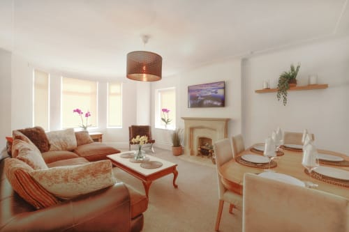 Dee-8 West Kirby lounge with coral furnishings, dining area, fireplace, and modern decor