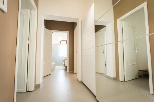 Modern villa hallway with white doors, mirrored walls, and neutral tones at Villa Maria, Sant'Andrea, Valderice, Sicily