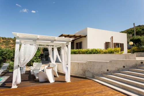 Modern white villa terrace with pergola, loungers, and sea view in Sant'Andrea, Sicily