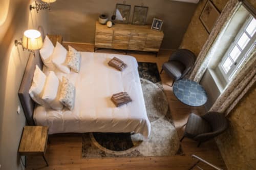 Chambre du Château Haut Clarise B&B à Belvès-de-Castillon avec lit blanc, commode en bois et coin détente