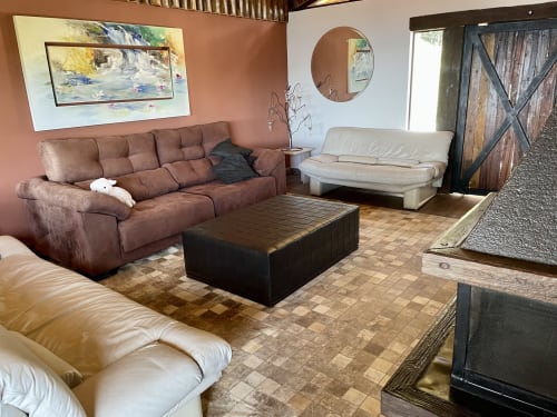 Aconchegante sala de estar da villa Paraíso nas Montanhas com sofá marrom, poltrona creme e vistas das montanhas em Campos do Jordão