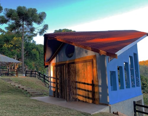 Vila azul com portas rústicas de madeira e telhado de metal corrugado no Paraíso nas Montanhas em Campos do Jordão, Brasil