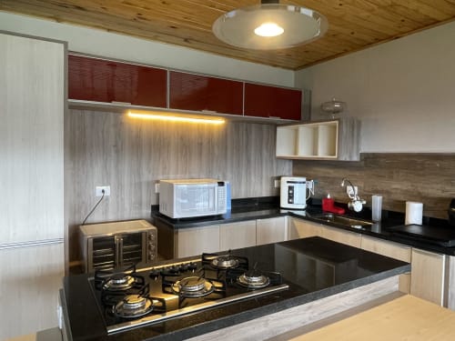 Cozinha moderna em villa na montanha, Paraíso nas Montanhas, Campos do Jordão, com cooktop a gás e bancadas pretas
