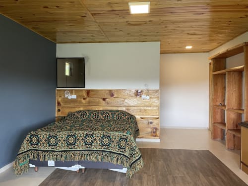 Quarto aconchegante na Paraíso nas Montanhas com teto de madeira, colcha decorativa, cabeceira rústica e vistas para as montanhas