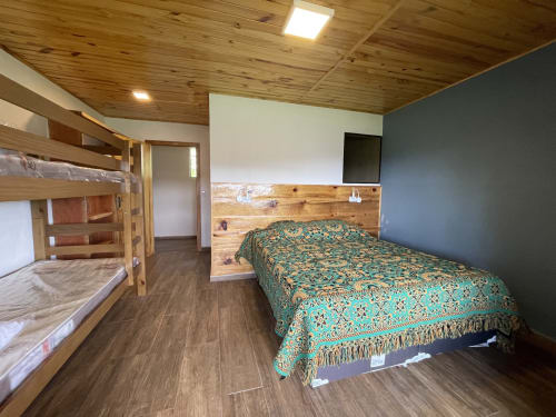 Quarto aconchegante da villa Paraíso nas Montanhas com camas beliche, cama queen, teto de madeira e vistas para as montanhas em Campos do Jordão