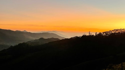 Pôr do sol dourado sobre montanhas em camadas em Campos do Jordão, Brasil no Paraíso nas Montanhas