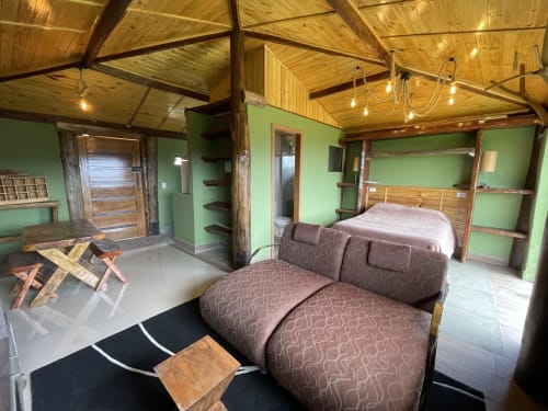 Quarto rústico na villa Paraíso nas Montanhas com paredes verdes, vigas de madeira e vista para as montanhas em Campos do Jordão