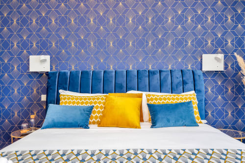 Camera lussuosa al SleepWithMe B&B Pisa con testata in velluto blu, carta da parati Art Deco e cuscini colorati