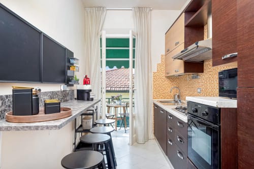 Cucina moderna con rivestimento in mattone e zona bar presso SleepWithMe Luxury B&B a Pisa, con accesso al patio del giardino