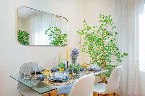 Elegante zona pranzo presso SleepWithMe Luxury B&B di Pisa con specchio dorato, piante e tavolo stilizzato