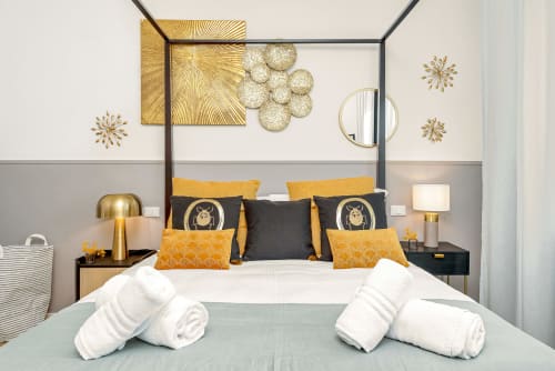 Camera da letto di lusso in stile BauHaus presso SleepWithMe B&B a Pisa con dettagli dorati, letto a baldacchino e vista sulla città