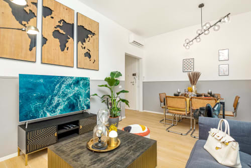 Lussuoso appartamento moderno allo SleepWithMe B&B di Pisa con elegante zona living, mappa del mondo e parete TV turchese