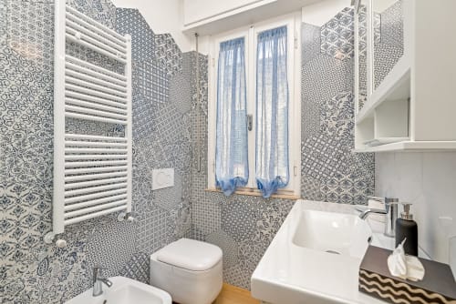 Bagno moderno nella Luxury B&B BauHaus di Pisa con piastrelle decorate, lavabo bianco, wc e scaldasalviette