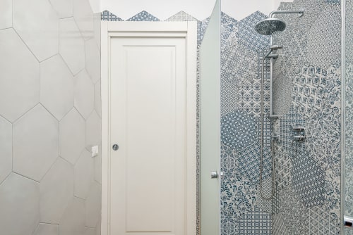 Bagno moderno presso SleepWithMe Luxury B&B a Pisa con piastrelle esagonali bianche, box doccia con motivi blu e