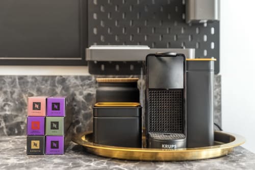 Macchina Nespresso con capsule di caffè su vassoi in ottone nell'appartamento di lusso BauHaus presso SleepWithMe, Pisa
