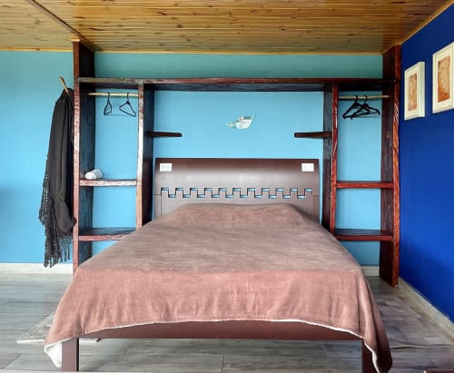 Suíte da villa Paraíso nas Montanhas com paredes turquesas, cama tipo dossel em madeira e decoração rústica em Campos do Jordão