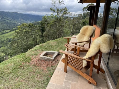Duas cadeiras Adirondack de madeira com mantas de lã de ovelha em terraço com vista de montanha no Paraíso nas Montanhas, Campos do Jordão