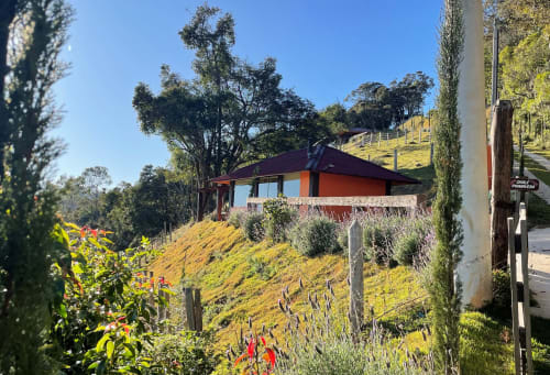 Villa Paraíso nas Montanhas em Campos do Jordão com estrutura de telhado vermelho com vista para a exuberante paisagem montanhosa